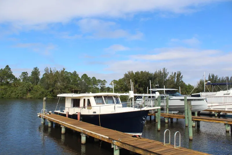 Getaway Yacht Photos Pics 2008 Mainship 34 Trawler Hardtop docked on a serene lake.