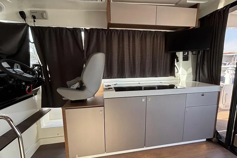  Yacht Photos Pics Interior of 2023 Beneteau Antares 11, featuring helm and modern kitchenette.