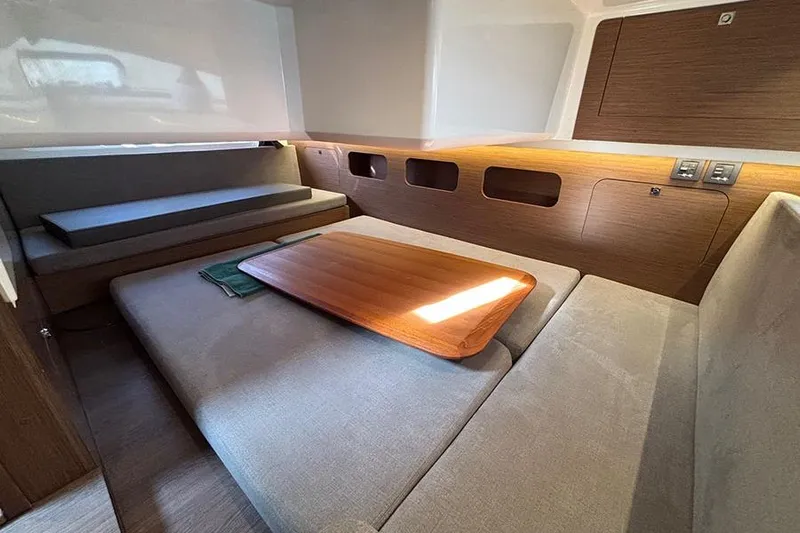  Yacht Photos Pics Interior of 2023 Beneteau Antares 11, featuring cozy seating and wooden table.