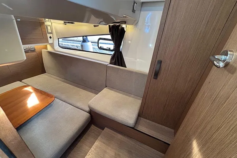  Yacht Photos Pics Interior of 2023 Beneteau Antares 11, featuring cozy seating and wooden accents.
