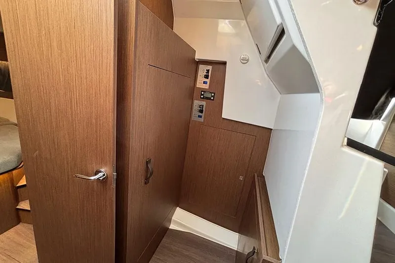  Yacht Photos Pics Interior view of 2023 Beneteau Antares 11, featuring wooden cabinetry and control panels.