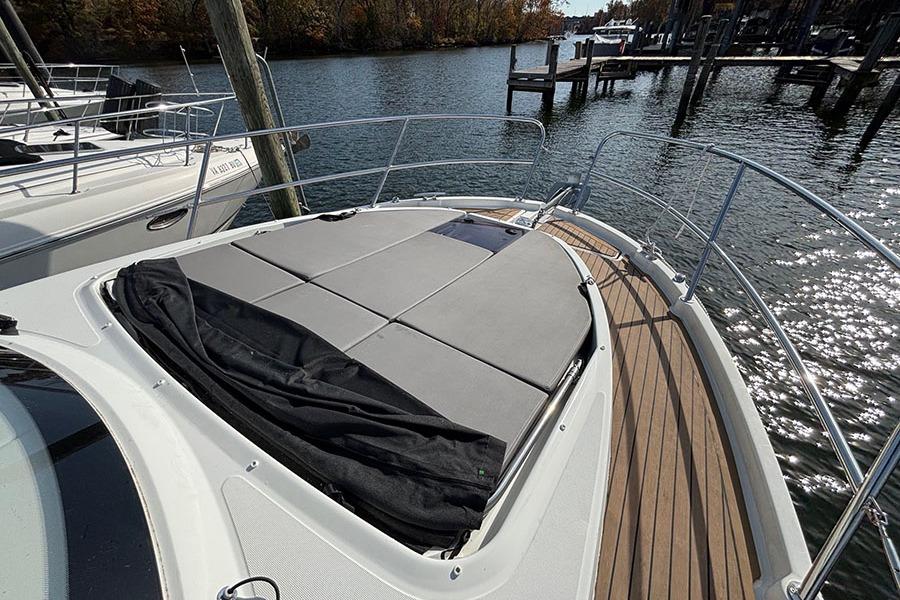 2023 Beneteau Antares 11 boat deck with sunbathing area on calm water.