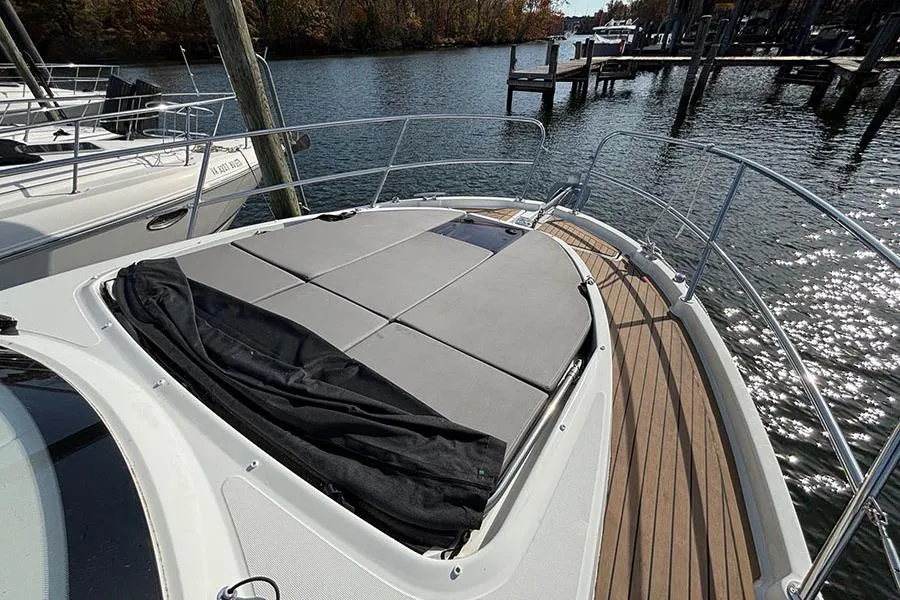 2023 Beneteau Antares 11 boat deck with sunbathing area on calm water.