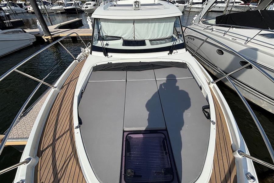 2023 Beneteau Antares 11 boat deck with sunbathing area, docked at marina.