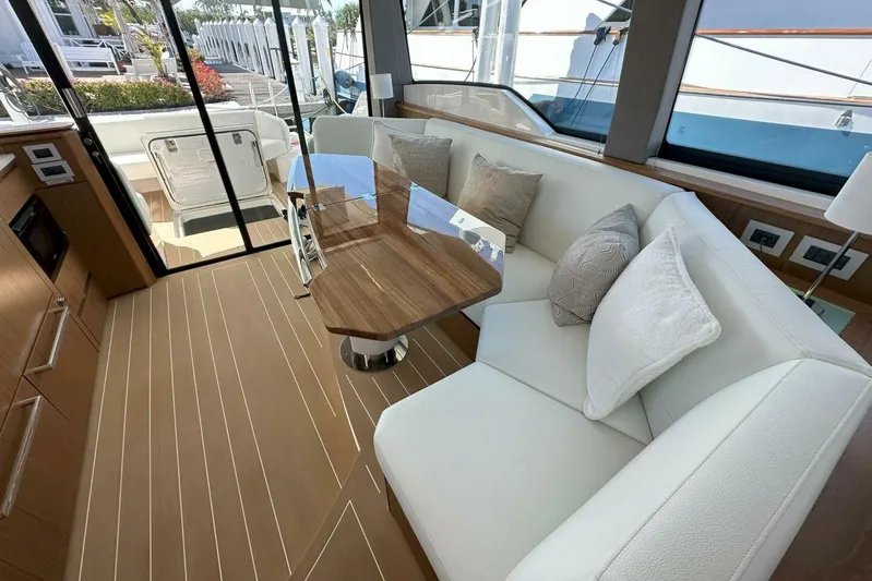 Just Fine Yacht Photos Pics Luxurious interior of 2025 Tiara Yachts EX 60 with elegant seating and wooden table.