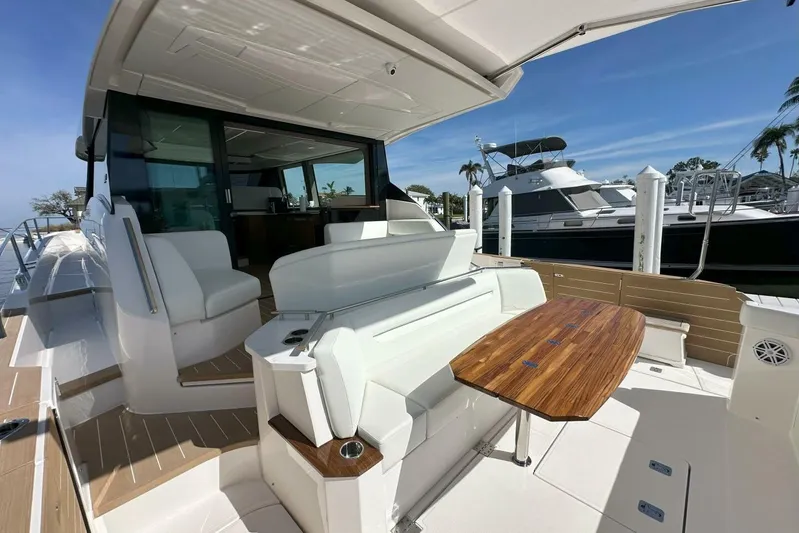 Just Fine Yacht Photos Pics 2025 Tiara Yachts EX 60 luxury yacht with elegant outdoor seating and wooden table.