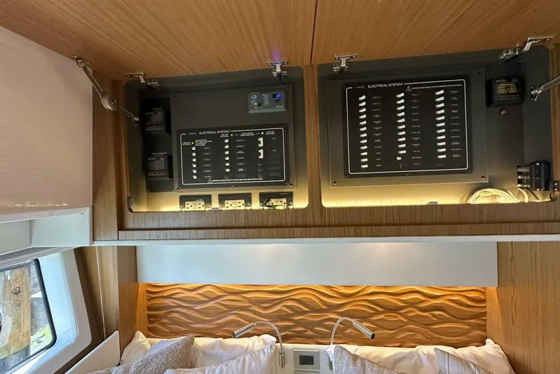 Just Fine Yacht Photos Pics 2025 Tiara Yachts EX 60 interior with electrical system panels above bed.