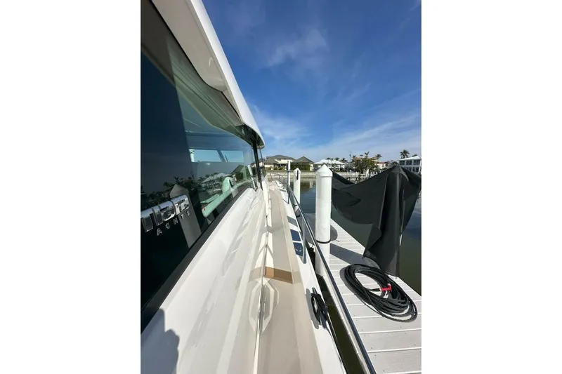 Just Fine Yacht Photos Pics 2025 Tiara Yachts EX 60 docked, showcasing sleek design and reflective windows.