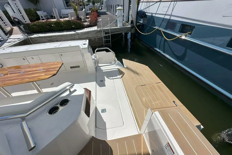 Just Fine Yacht Photos Pics 2025 Tiara Yachts EX 60 deck with wooden table and dock view.