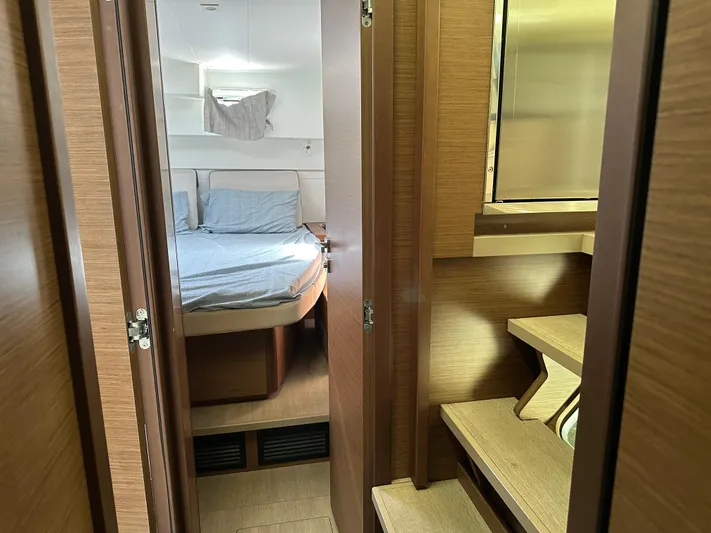  Yacht Photos Pics Interior of 2020 Lagoon 40 catamaran, featuring a cozy bedroom with wooden finishes.