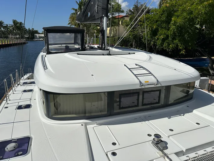  Yacht Photos Pics 2020 Lagoon 40 catamaran on a sunny day, docked by a canal with lush greenery.