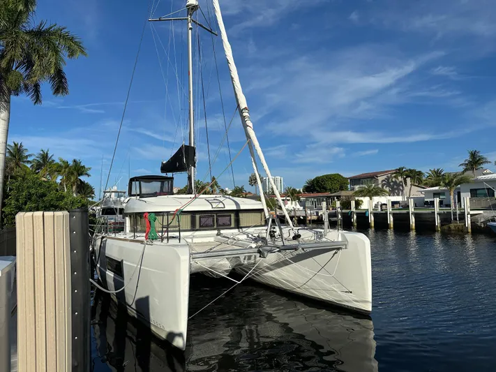 Yacht Photos Pics 2020 Lagoon 40 catamaran docked in a sunny marina, surrounded by palm trees.