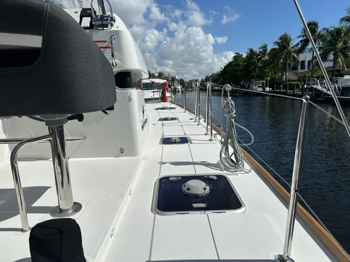  Yacht Photos Pics 2020 Lagoon 40 catamaran deck view, docked by a canal with palm trees.