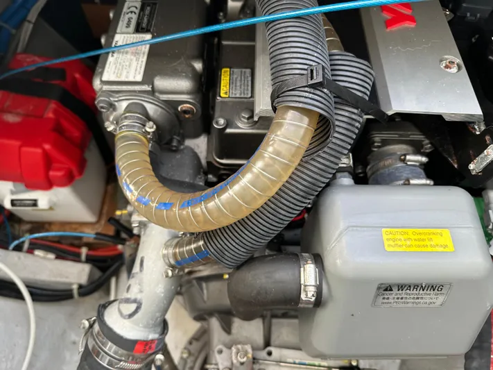  Yacht Photos Pics Engine compartment of a 2020 Lagoon 40 catamaran, showing hoses and warning labels.
