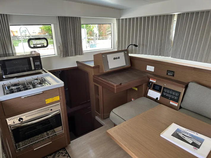  Yacht Photos Pics Modern interior of 2020 Lagoon 40 catamaran with kitchen and navigation station.