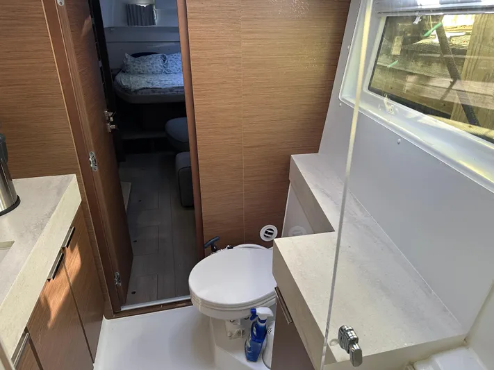  Yacht Photos Pics Interior of 2020 Lagoon 40 catamaran bathroom with modern fixtures and adjacent bedroom.