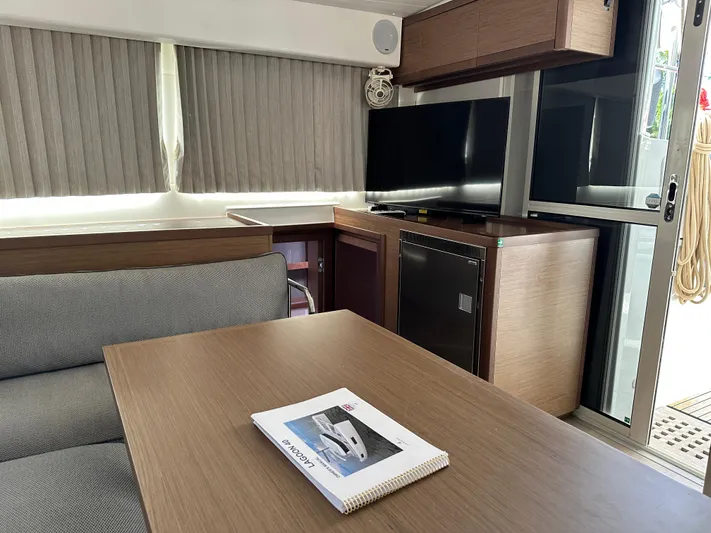  Yacht Photos Pics Interior of 2020 Lagoon 40 catamaran with modern furnishings and a manual on the table.
