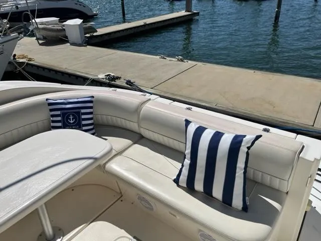 True Blue Yacht Photos Pics 2003 Cruisers Yachts 3772 Express boat with striped cushions docked at marina.