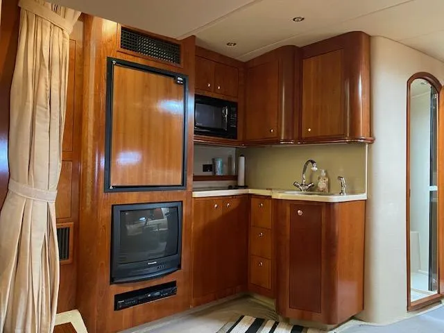 True Blue Yacht Photos Pics 2003 Cruisers Yachts 3772 Express interior with kitchenette and entertainment center.