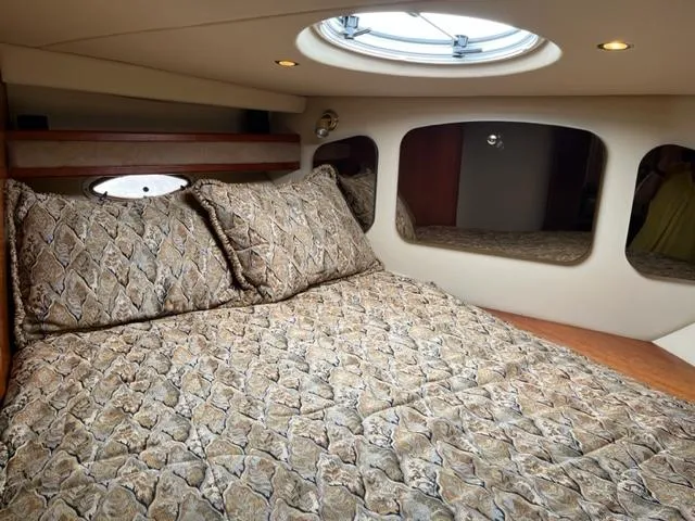 True Blue Yacht Photos Pics 2003 Cruisers Yachts 3772 Express cabin with patterned bedding and porthole window.