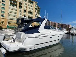 True Blue Yacht Photos Pics 2003 Cruisers Yachts 3772 Express docked in a marina with buildings in the background.