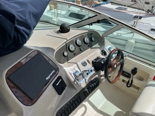 True Blue Yacht Photos Pics 2003 Cruisers Yachts 3772 Express helm with Raymarine electronics and wood-accented steering wheel.