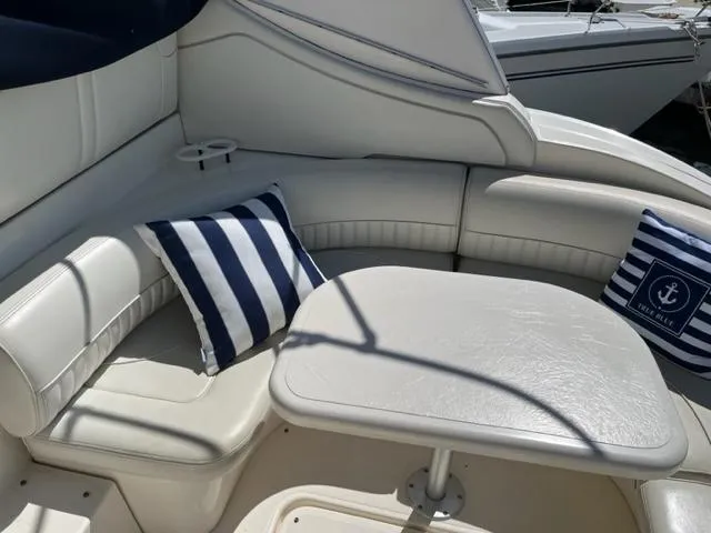 True Blue Yacht Photos Pics 2003 Cruisers Yachts 3772 Express interior seating area with striped cushions and table.