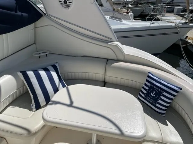 True Blue Yacht Photos Pics 2003 Cruisers Yachts 3772 Express interior with striped cushions and table.
