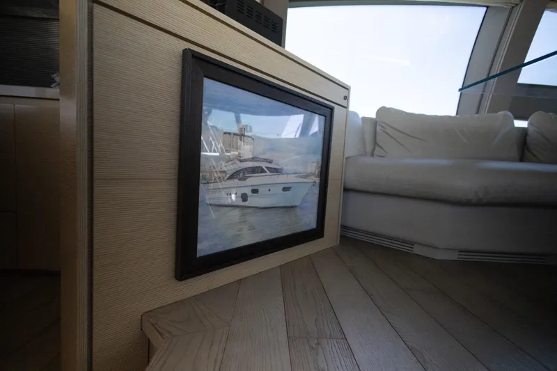 Navegante Yacht Photos Pics Interior of 2013 Ferretti Yachts 690 with framed yacht picture and white sofa.