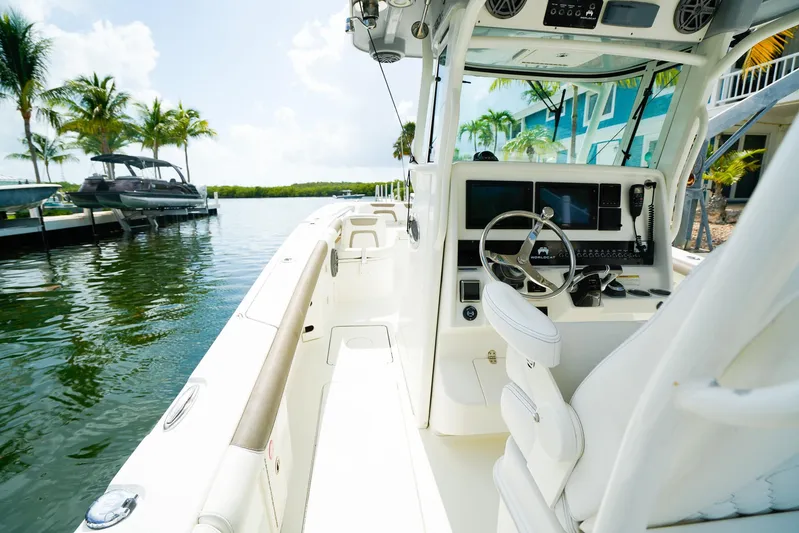Complete Lunasea Yacht Photos Pics 2018 World Cat 320 CC boat interior with steering wheel, docked near palm trees.