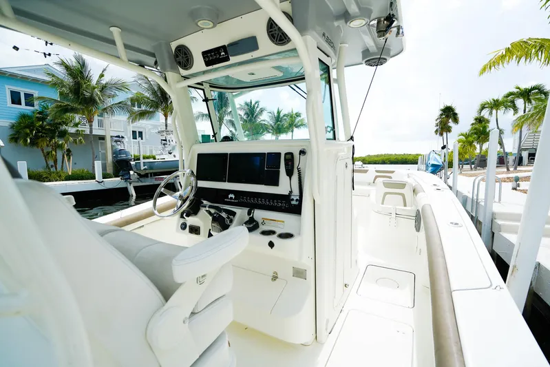 Complete Lunasea Yacht Photos Pics 2018 World Cat 320 CC boat interior with steering wheel and control panel, docked near palm trees.
