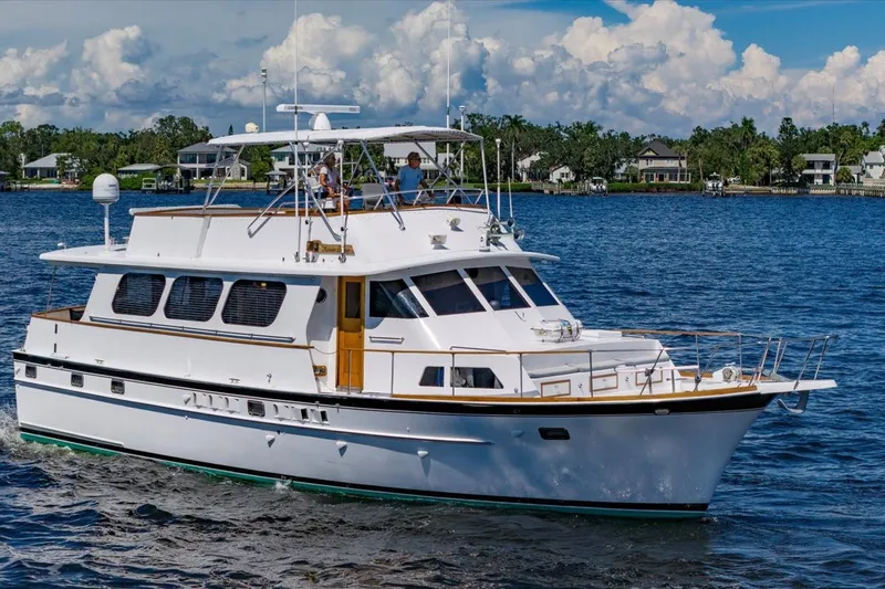  Yacht Photos Pics 1971 Matthews Voyager yacht cruising on a serene lake with houses in the background.