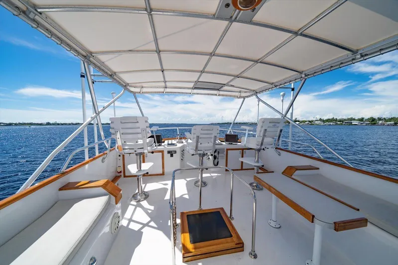  Yacht Photos Pics 1971 Matthews Voyager boat deck with seating, helm, and canopy on a sunny day.