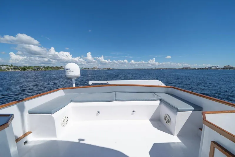  Yacht Photos Pics 1971 Matthews Voyager boat deck with cushioned seating, overlooking calm blue waters and clear sky.