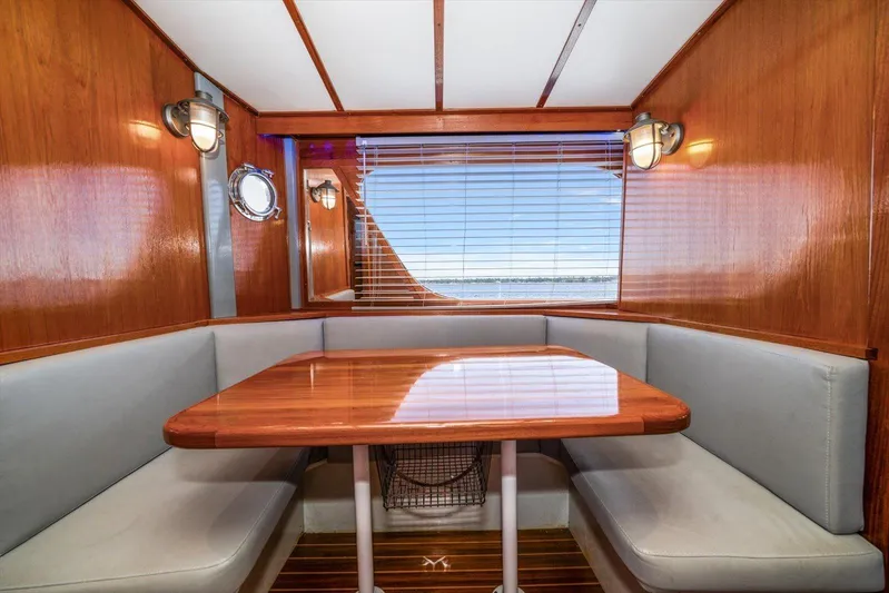  Yacht Photos Pics Cozy dining area in 1971 Matthews Voyager boat with wooden table and cushioned seating.