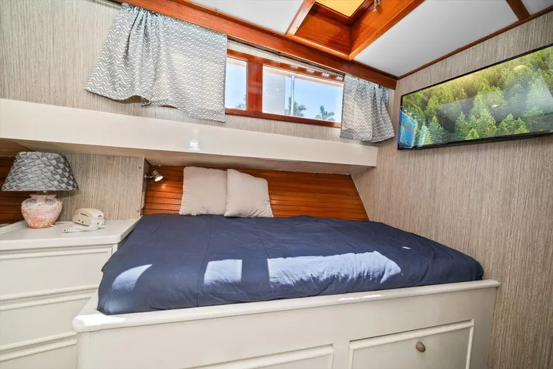 Yacht Photos Pics Cozy cabin bedroom in 1971 Matthews Voyager boat with blue bedding and scenic wall art.