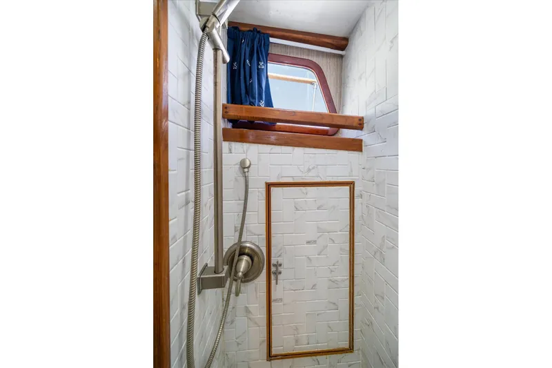  Yacht Photos Pics Shower area in 1971 Matthews Voyager boat with white tiles and wooden accents.