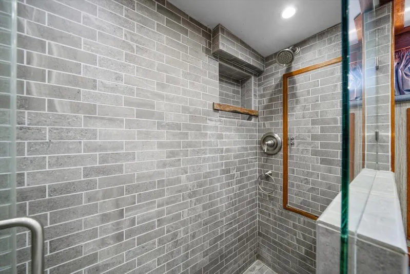  Yacht Photos Pics Modern shower with gray brick tiles, glass door, and wooden accents in a 1971 Matthews Voyager.