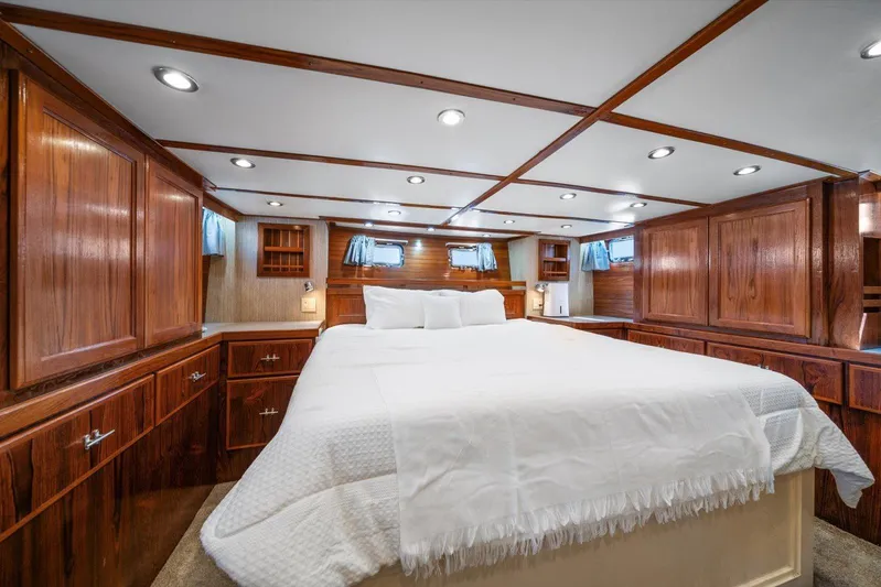  Yacht Photos Pics Luxurious 1971 Matthews Voyager yacht bedroom with wood paneling and cozy bedding.