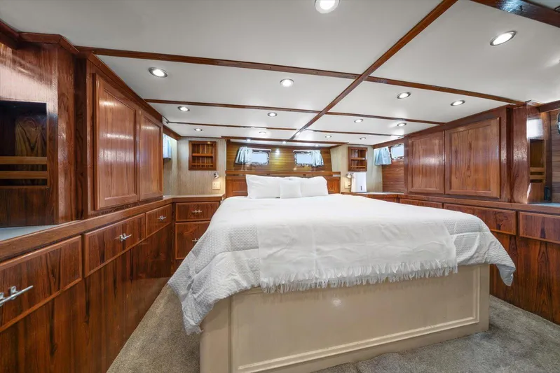  Yacht Photos Pics Luxurious 1971 Matthews Voyager yacht bedroom with wood paneling and cozy bedding.