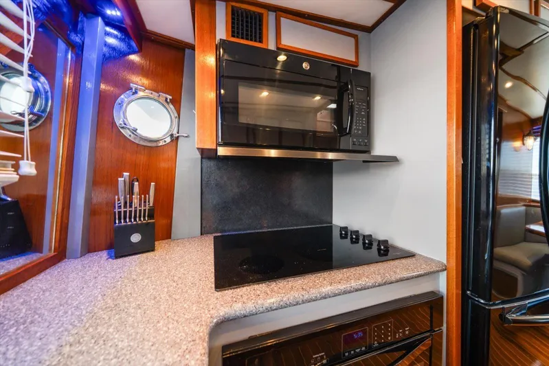  Yacht Photos Pics Modern kitchen in 1971 Matthews Voyager yacht with microwave, stovetop, and porthole window.