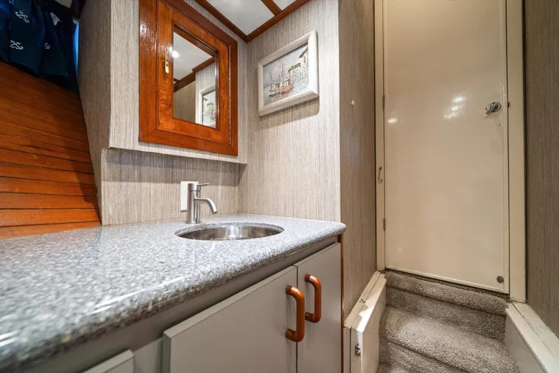  Yacht Photos Pics 1971 Matthews Voyager bathroom with granite countertop, wooden mirror, and carpeted stairs.