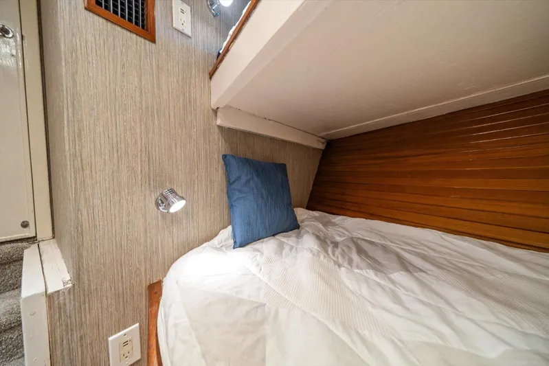  Yacht Photos Pics Cozy cabin bed in 1971 Matthews Voyager with wood paneling and reading light.