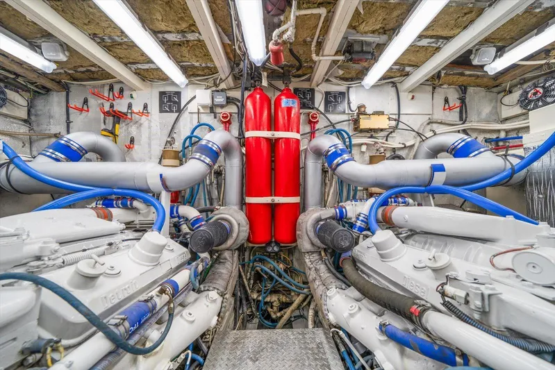  Yacht Photos Pics Engine room of a 1971 Matthews Voyager boat with visible machinery and red fire extinguishers.