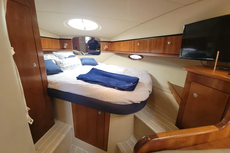 Grandcru Yacht Photos Pics Luxurious cabin interior of 2005 Cruisers Yachts 340 Express with cozy bed and TV.