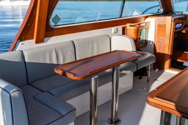 Theresa Anne III Yacht Photos Pics Interior of 2012 Hunt Yachts Harrier 36 Express with wooden table and seating.