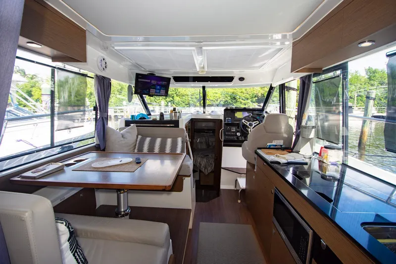 Sea Scape Yacht Photos Pics Interior of 2021 Jeanneau NC 1095 boat, featuring modern kitchen and seating area.