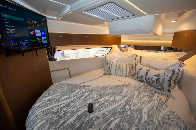 Sea Scape Yacht Photos Pics Luxurious cabin interior of 2021 Jeanneau NC 1095 with cozy bed and mounted TV.