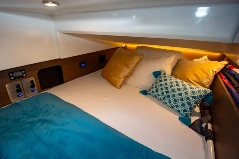 Sea Scape Yacht Photos Pics Cozy cabin interior of 2021 Jeanneau NC 1095 with plush bedding and ambient lighting.