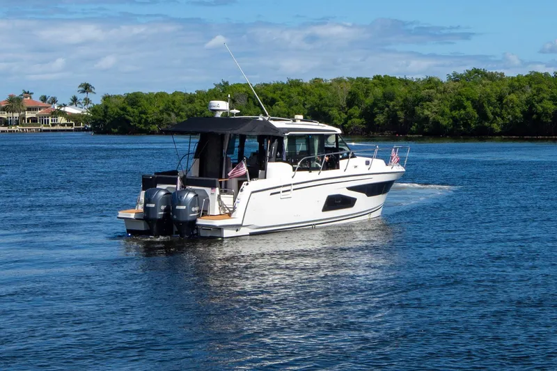 Sea Scape Yacht Photos Pics 2021 Jeanneau NC 1095 motorboat cruising on a scenic waterway.